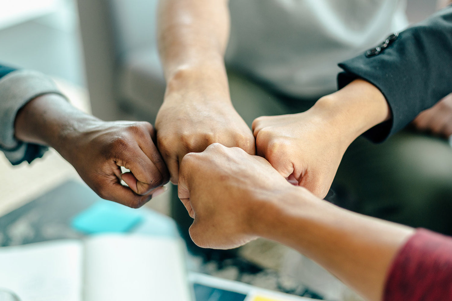 A group of people fist bumping