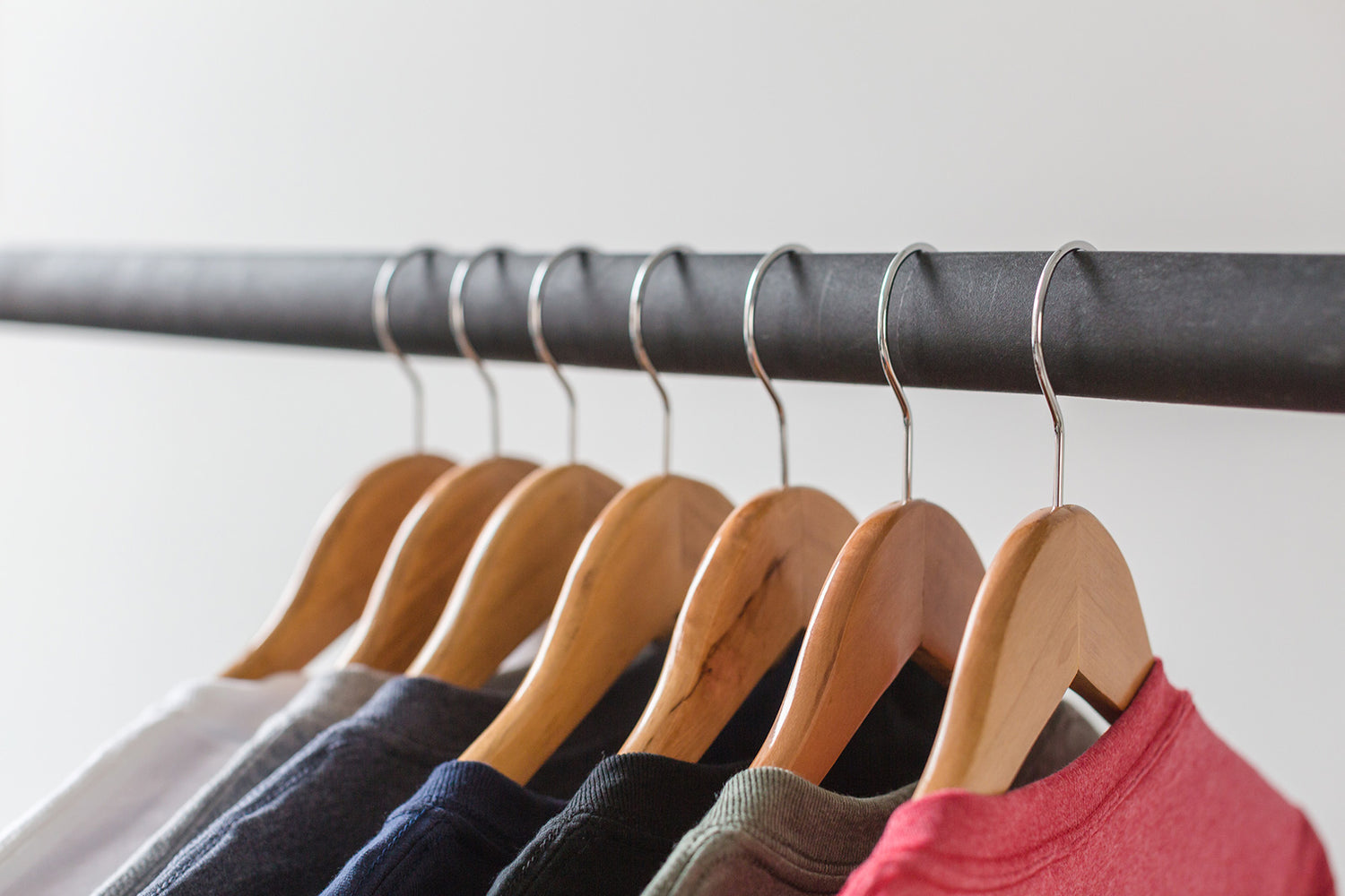 colored t-shirts hanging neatly from a bar